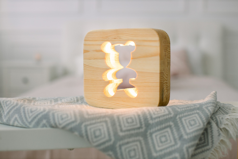 Alt: Đèn ngủ gỗ ánh vàng nhẹ.