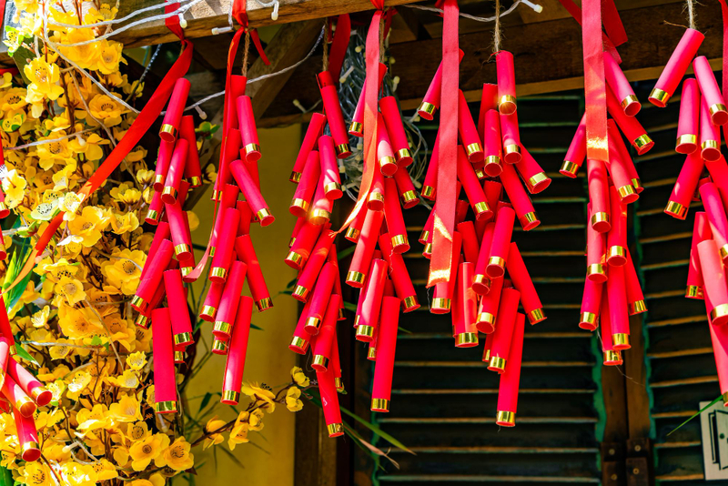 Alt: Cách trang trí Tết mầm non bằng dây pháo giấy màu đỏ treo tường lớp học.